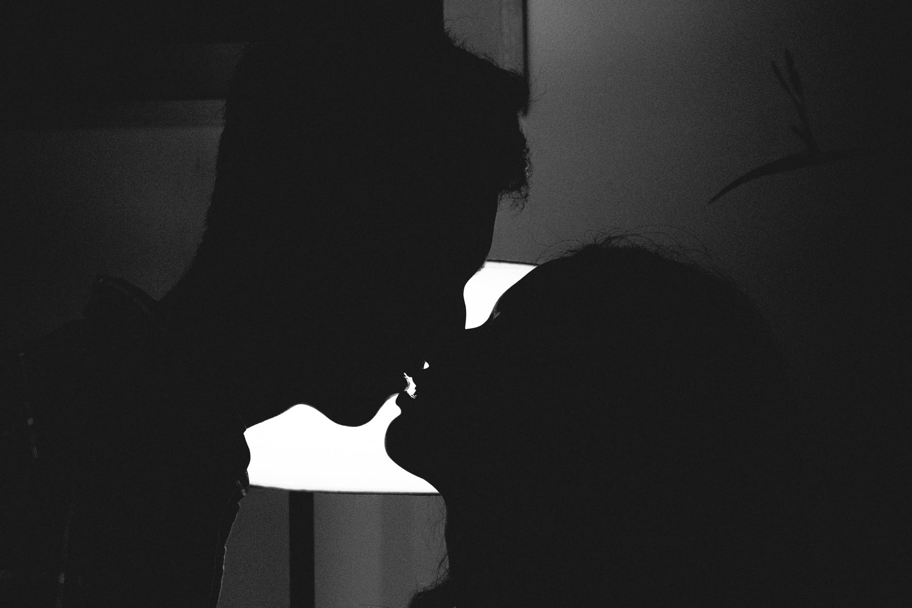 silhouette photo of man and woman kissing
